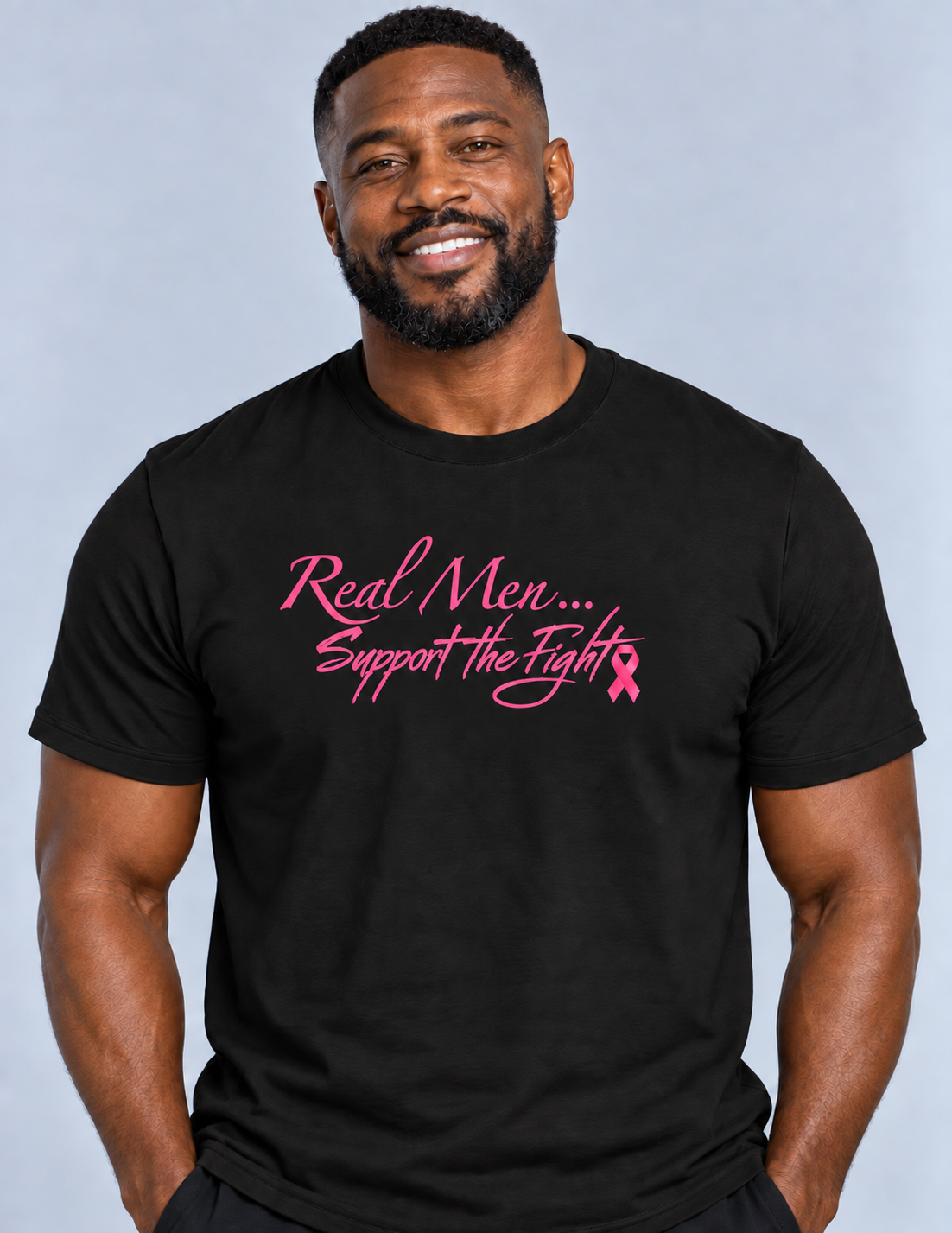 Model wearing black Real Men… Support the Fight unisex T-shirt with pink lettering and ribbon