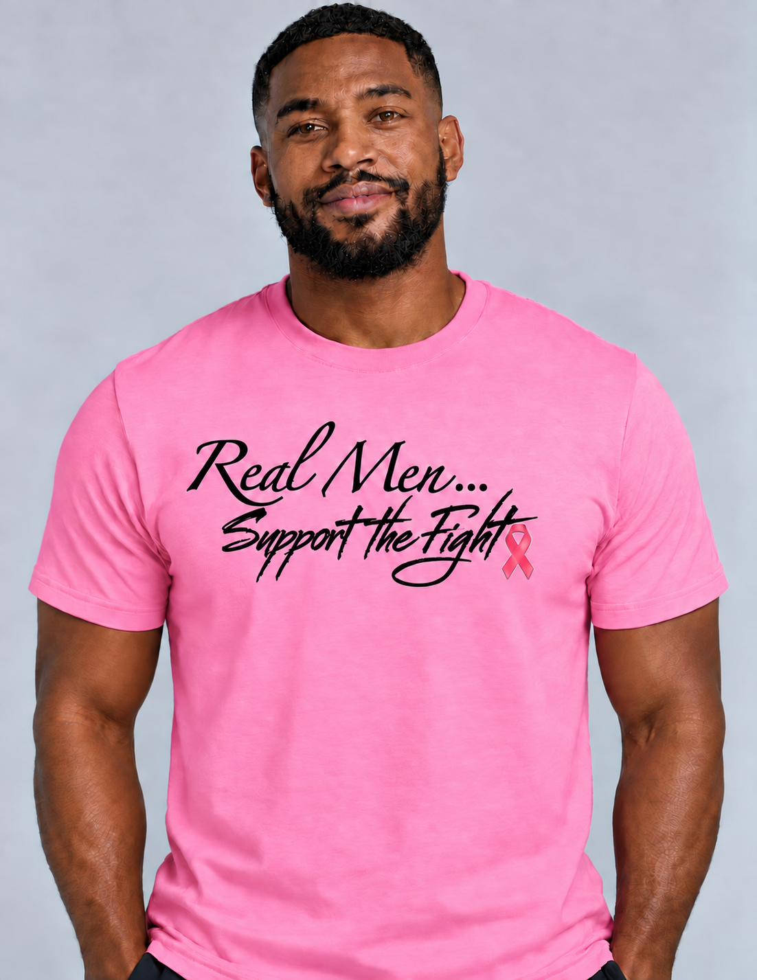 Model wearing pink Real Men… Support the Fight unisex T-shirt with black lettering and pink ribbon