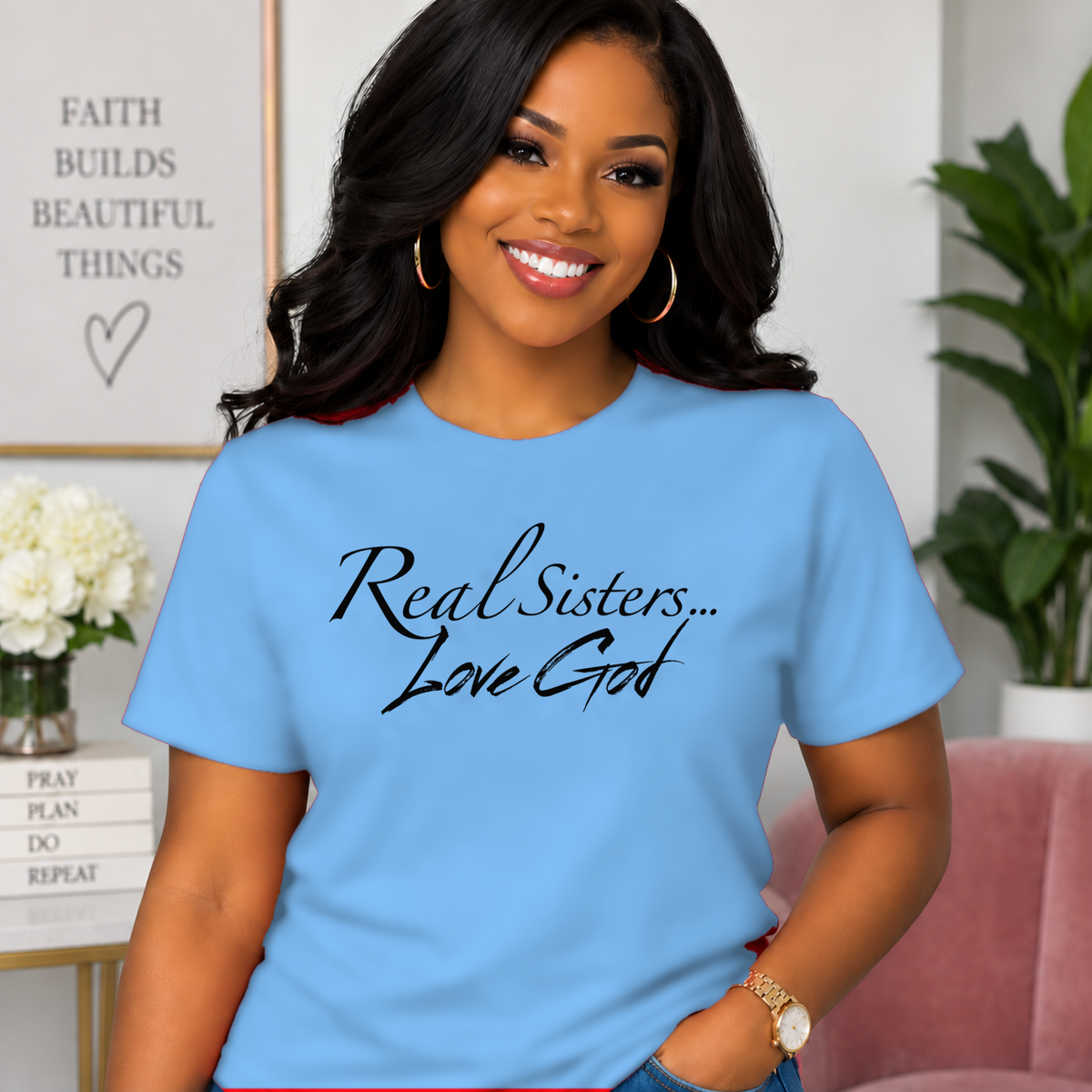 Model wearing Carolina Blue Real Sisters Love God T-shirt with Black lettering, crisp original logo