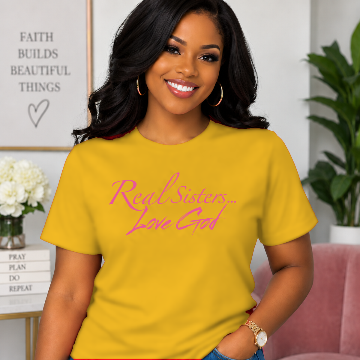 Model wearing Gold Real Sisters Love God T-shirt with Pink lettering, crisp original logo