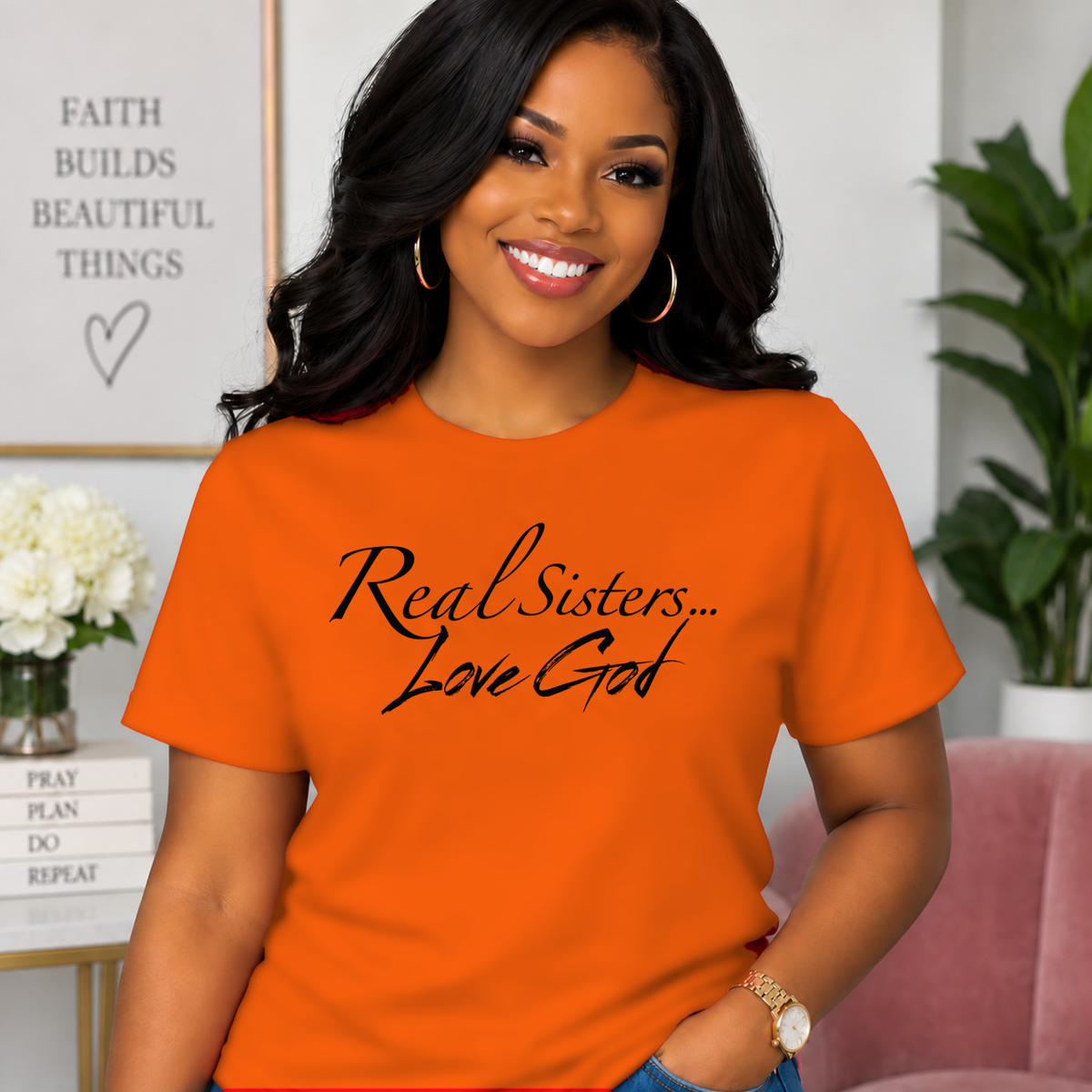 Model wearing Orange Real Sisters Love God T-shirt with Black lettering, crisp original logo