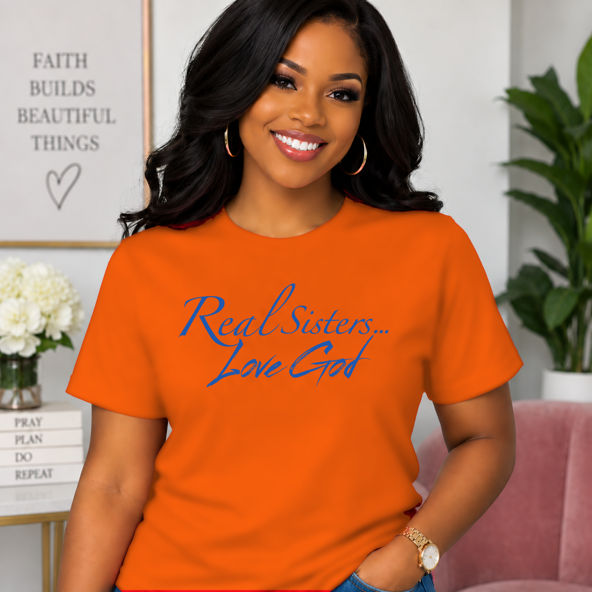 Model wearing Orange Real Sisters Love God T-shirt with Blue lettering, crisp original logo