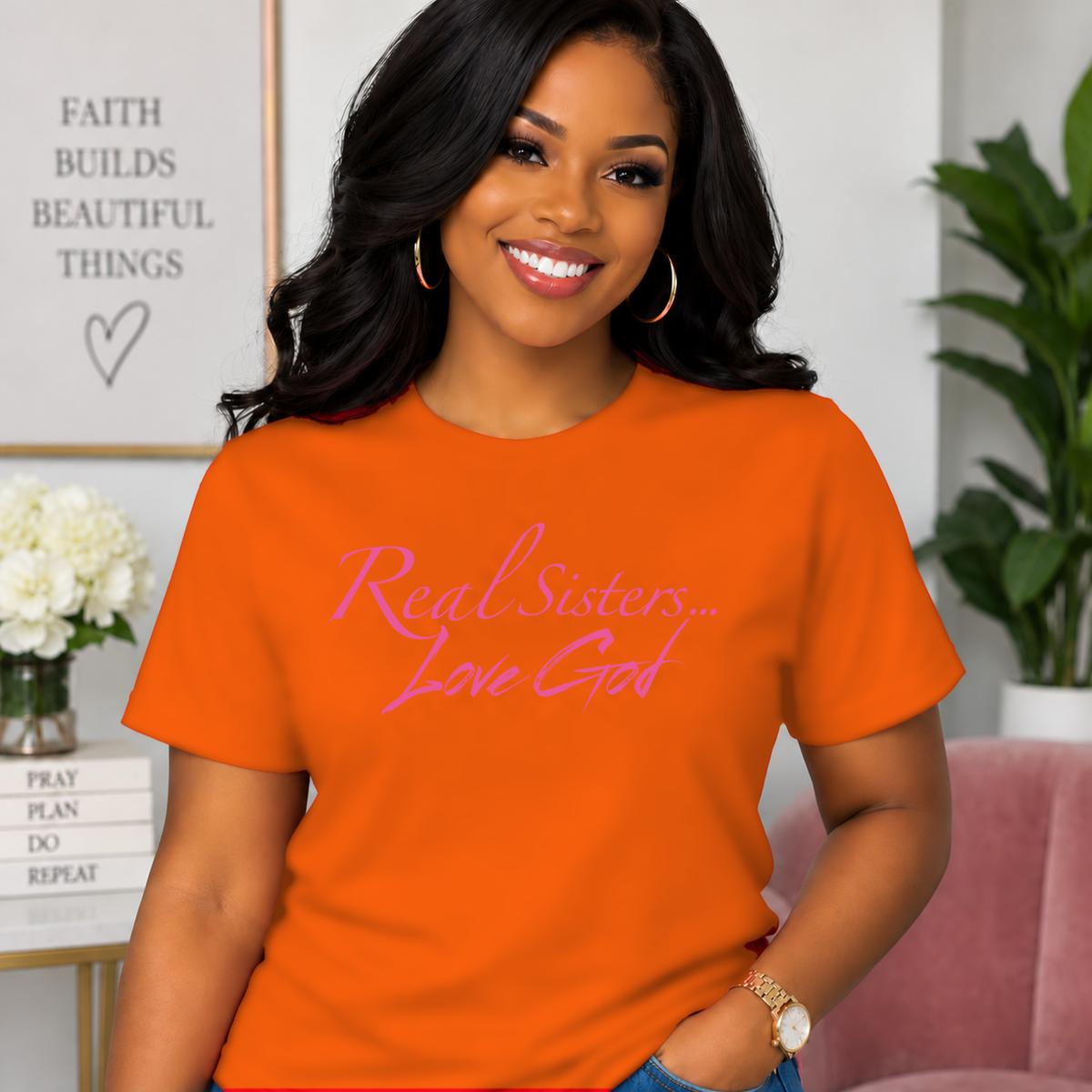 Model wearing Orange Real Sisters Love God T-shirt with Pink lettering, crisp original logo